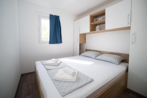 穆泰尔岛Mobile Home Lana的一间小卧室,配有一张白色的床和窗户