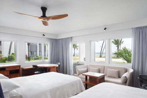 丹娜努Sheraton Fiji Golf & Beach Resort的酒店客房设有两张床和窗户。