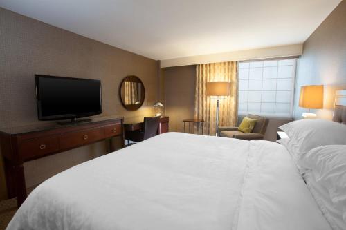 科里奥波利斯匹兹堡机场喜来登酒店的配有一张床和一台平面电视的酒店客房