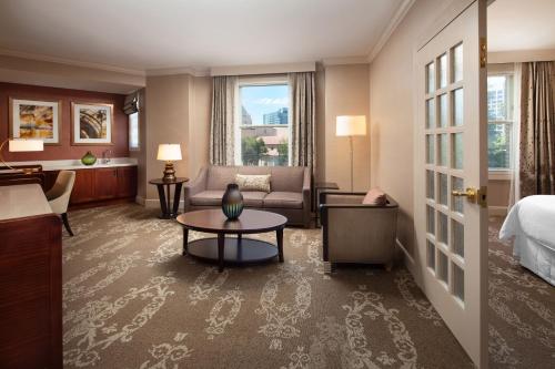 圣何塞威斯汀圣何塞酒店的酒店客房配有床、沙发和桌子。