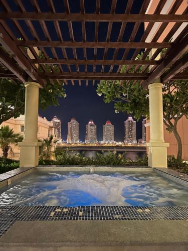 多哈Beachfront Luxury Apartment-The Home-Pearl Island的一座位于凉亭下的游泳池,享有城市天际线