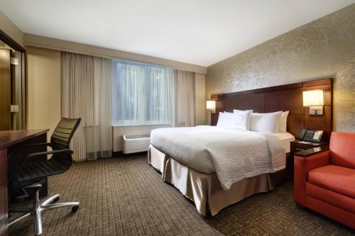 纽约时代广场西万怡酒店的酒店客房配有一张床、一张桌子和一把椅子。