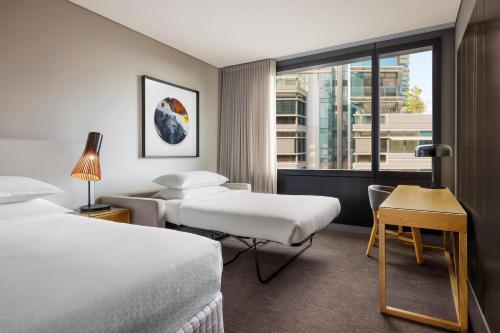 悉尼悉尼中央公园福朋喜来登酒店的酒店客房设有两张床和窗户。