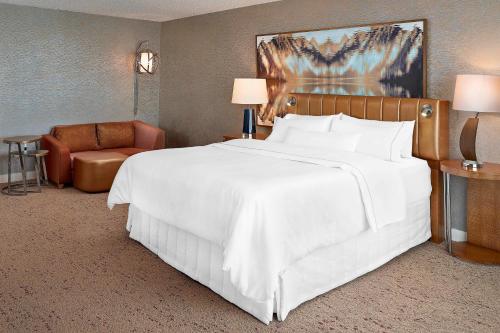 埃德蒙顿埃德蒙顿威斯汀酒店的卧室配有一张白色大床和一把椅子
