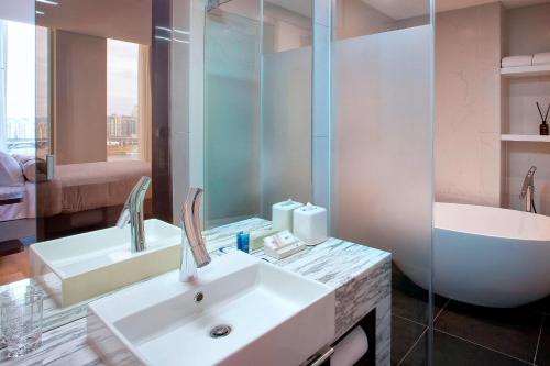首尔首尔江南雅乐轩酒店的浴室配有水槽、淋浴和浴缸。