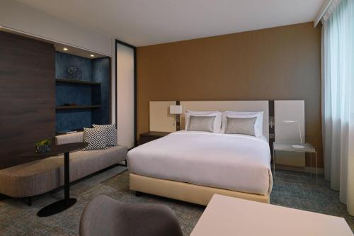 布拉尼亚克Residence Inn by Marriott Toulouse-Blagnac的卧室配有一张白色大床和一张书桌