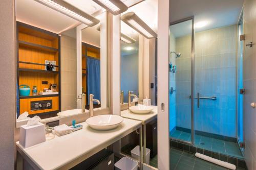 波特兰喀斯喀特车站雅乐轩波特兰机场酒店的一间带两个盥洗盆和淋浴的浴室