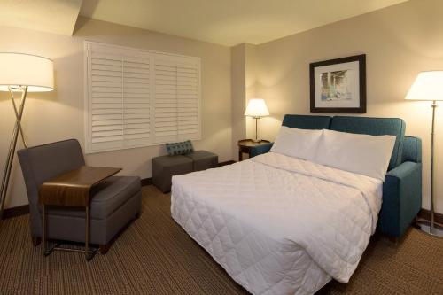 可可比奇可可海滩福朋喜来登酒店的配有一张床和一把椅子的酒店客房