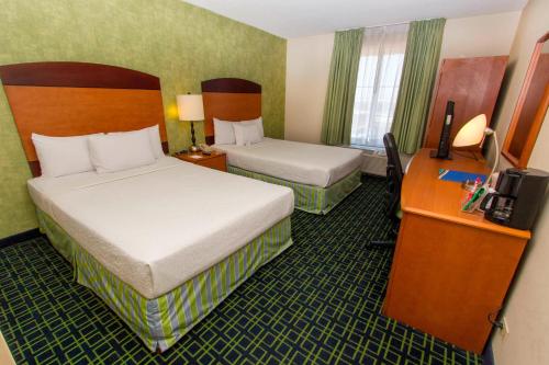 蒙特雷Wyndham Garden Monterrey Aeropuerto的酒店客房配有两张床和一张书桌