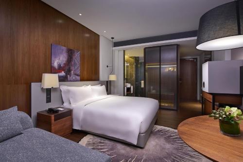 八打灵再也Le Meridien Petaling Jaya的卧室配有一张白色的大床和一张沙发。