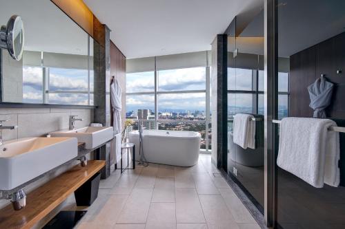 八打灵再也Le Meridien Petaling Jaya的一间带两个盥洗盆、浴缸和窗户的浴室