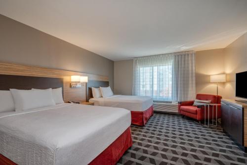 印第安纳波利斯TownePlace Suites by Marriott Indianapolis Airport的酒店客房设有两张床和电视。