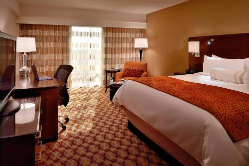 路易斯威尔Marriott Louisville East的酒店客房配有一张床、一张书桌和一台笔记本电脑