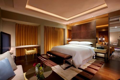 竹北新竹丰邑喜来登大饭店的一间带大床的卧室和一间客厅