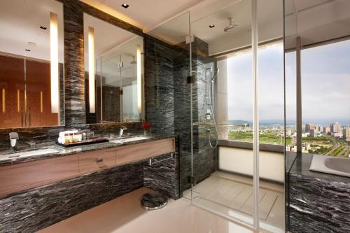 竹北新竹丰邑喜来登大饭店的一间带玻璃淋浴和水槽的浴室