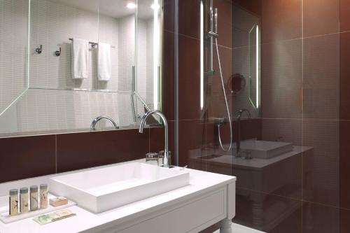 吕埃尔-马尔迈松巴黎竞技场圣克劳德万丽酒店的浴室设有白色水槽和镜子