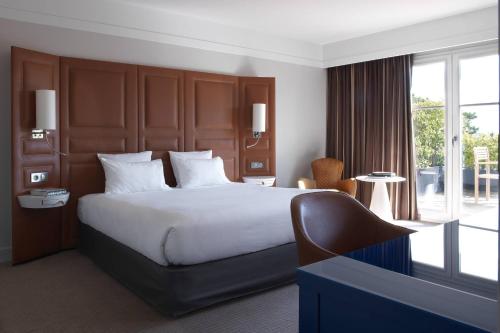 吕埃尔-马尔迈松巴黎竞技场圣克劳德万丽酒店的酒店客房设有一张床和一个大窗户