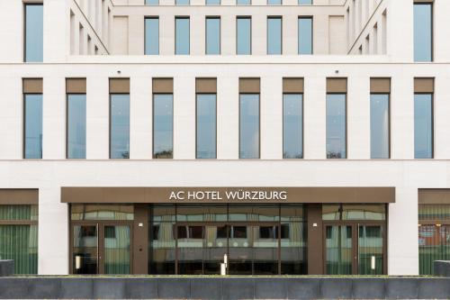 维尔茨堡AC Hotel by Marriott Wuerzburg的带有指示牌的办公楼,上面写着ac酒店退出的标志