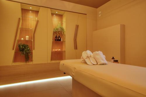 代森扎诺-德尔加达Hotel Palazzo del Garda & Spa的一间位于客房内床上的带毛巾的浴室