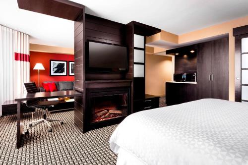 米西索加米西索加梅德维尔福朋喜来登酒店的酒店客房配有一张床、一张书桌和一台电视。