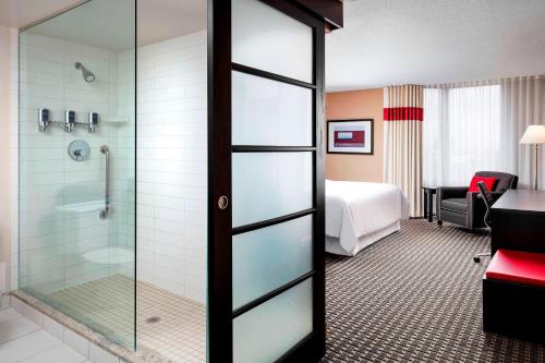 米西索加米西索加梅德维尔福朋喜来登酒店的酒店客房设有淋浴和一间卧室。