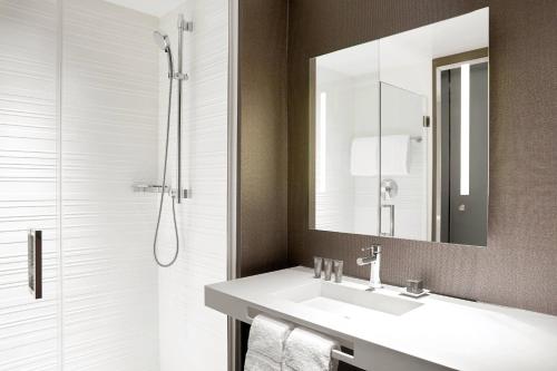 尔湾欧文万豪AC 酒店的一间带水槽、镜子和淋浴的浴室