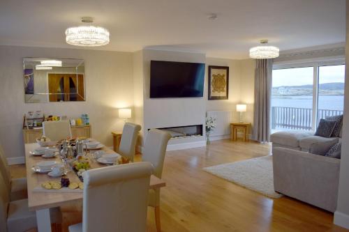 LeverburghGrimisdale Guest House的用餐室以及带桌椅的起居室。