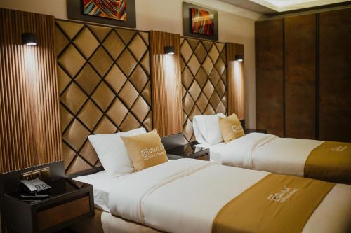 阿克萨赖QUALA HOTELS & LOUNGE的酒店客房带两张床和电话