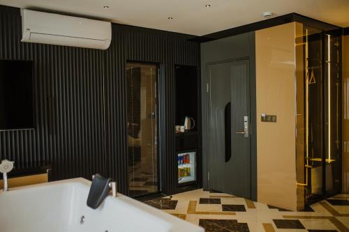 阿克萨赖QUALA HOTELS & LOUNGE的带浴缸和黑色墙壁的浴室