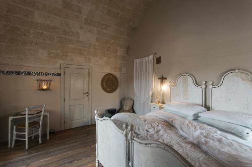 马泰拉科尔特圣莱昂纳多旅馆的卧室配有白色的床和桌子