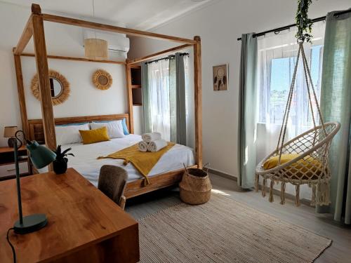 格兰贝伊Villa le Dodo - GBH的卧室配有带秋千和桌子的床