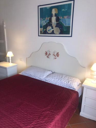 斯廷蒂诺Stintino Appartamento Country Bagaglino - Anna -的一间卧室配有一张红色床罩的床