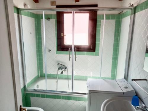 斯廷蒂诺Stintino Appartamento Country Bagaglino - Anna -的绿色和白色的浴室设有淋浴和水槽