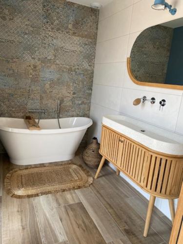 La GenilliereVilla contemporaine La Rochelle的带浴缸、水槽和镜子的浴室