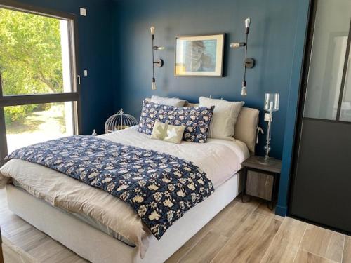 La GenilliereVilla contemporaine La Rochelle的一间卧室配有一张蓝色墙壁的床和一扇窗户