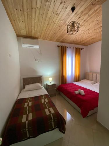KomanLugina e Komanit的一间带两张床的卧室,位于木天花板的房间