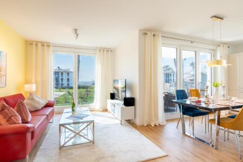 加兹尤瑟多姆Apartment "Wikinger Exklusiv" - Haffresidenz的客厅配有红色的沙发和桌子