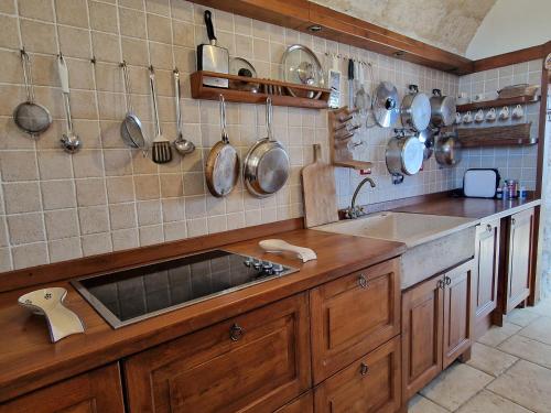 莱乌卡Oliventu - Tra gli ulivi sul mare的厨房设有水槽和墙上的锅碗瓢盆