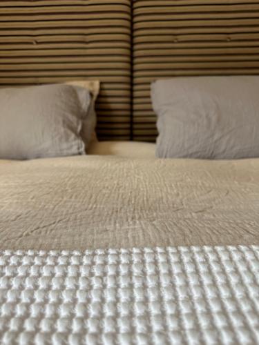 VillarogerChalet Violettes的一张带白色床单的床和两个枕头