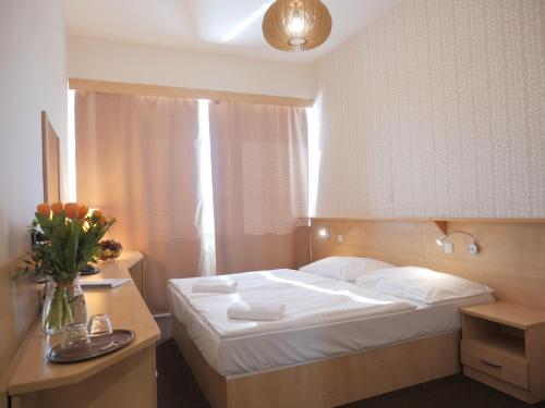 布拉格阿必托酒店的一间卧室,配有一张床和花瓶