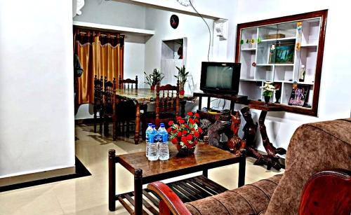 德维科拉姆Suryas Home Stay的客厅配有沙发和鲜花桌