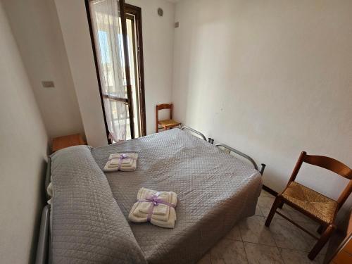 加里波第港Appartamento a Porto Garibaldi vicino al mare的一间卧室配有一张床,并备有2个拖鞋