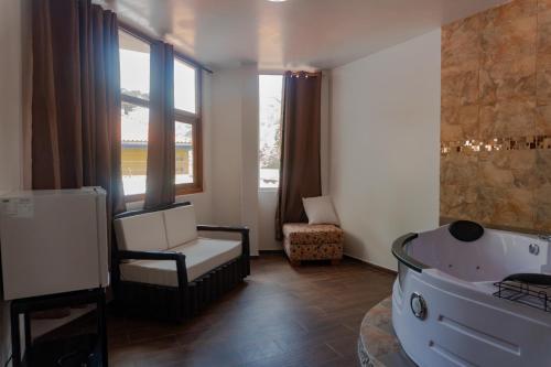 巴尼奥斯Hotel De Mi Pueblo的带浴缸、椅子和窗户的浴室