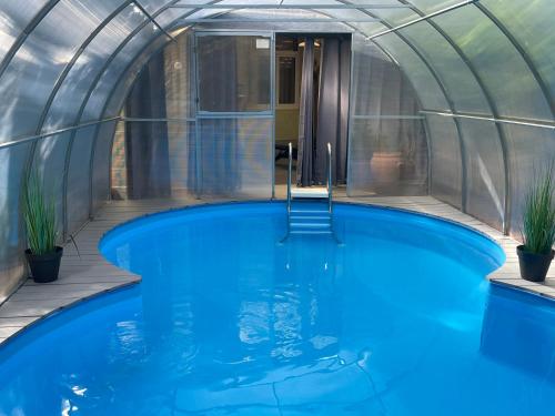 塔勒Harzhotel Warnstedter Krug的蓝色水圆顶房屋内的室内游泳池