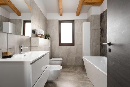 波雷奇Casa Pinia with outdoor jacuzzi的一间带水槽、浴缸和卫生间的浴室