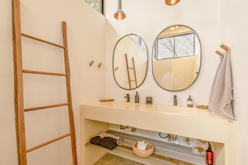 诺萨拉Casa Arcilla NEW LISTING的一间带水槽和两面镜子的浴室