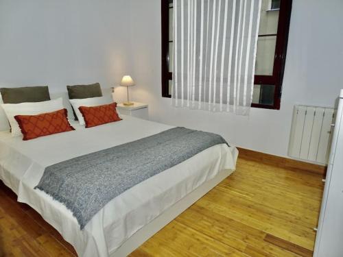 马德里Apartamento con encanto junto a la Plaza Mayor的卧室配有带红色枕头的大型白色床