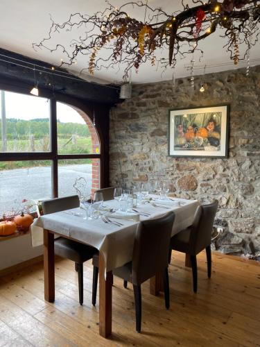 韦姆La Trouvaille的一间设有桌子和石墙的用餐室