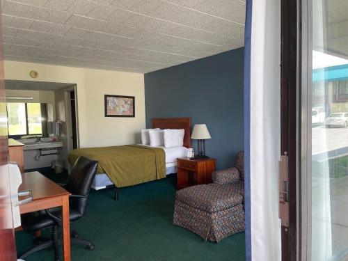 阿尔图纳Horseshoe Curve Lodge的酒店客房,配有一张床、一张桌子和椅子