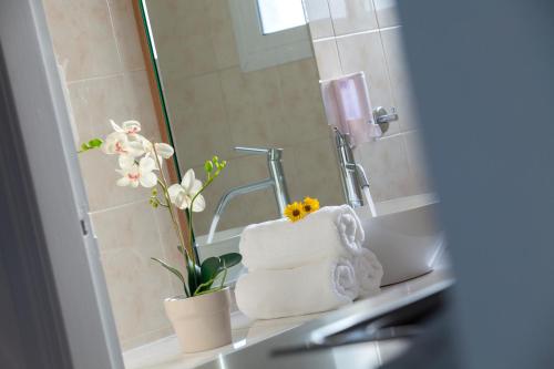 帕福斯普林斯萨维拉公寓式酒店的浴室设有水槽、毛巾和镜子
